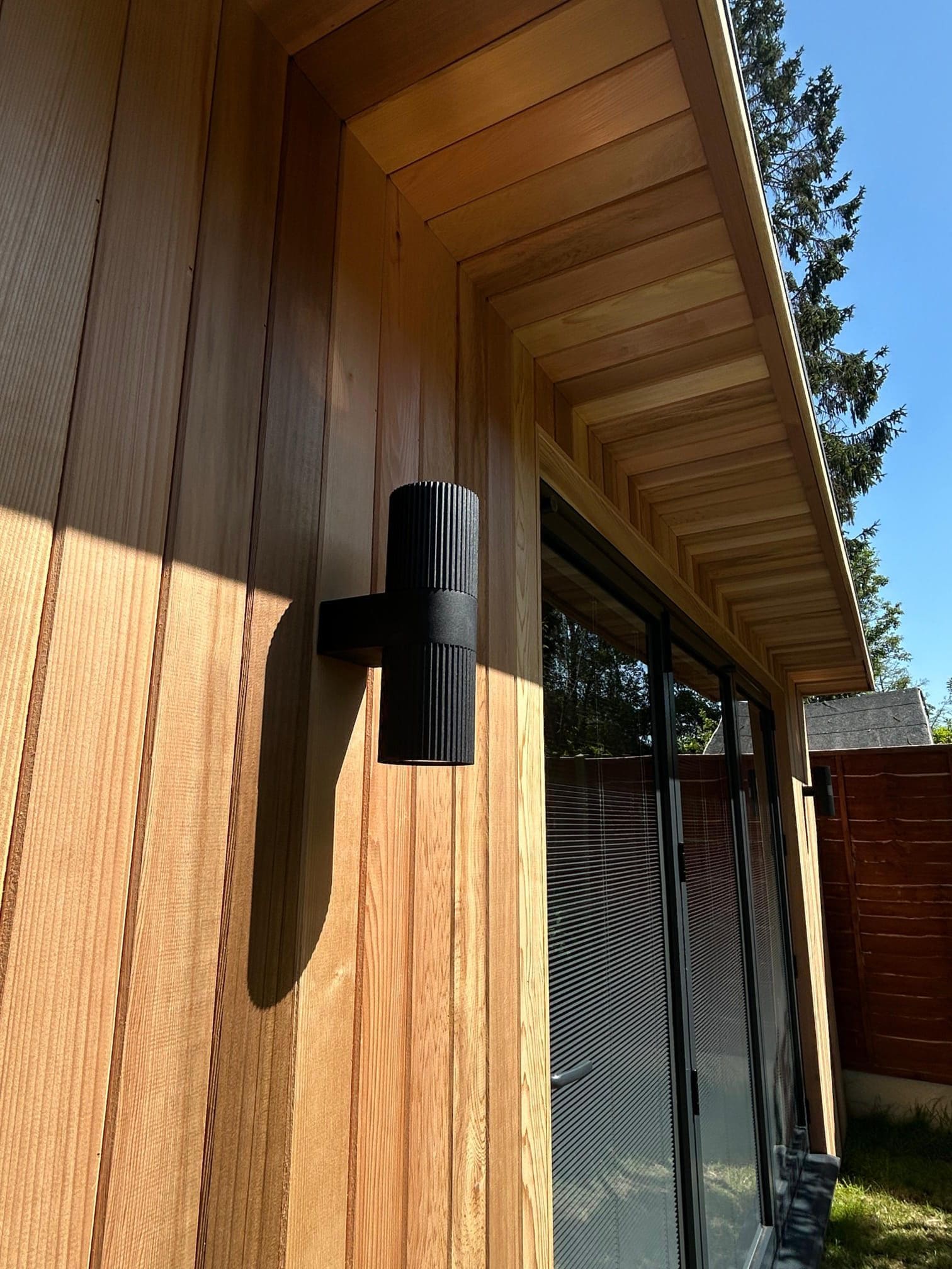 Cedar garden room with Nordlux wall light