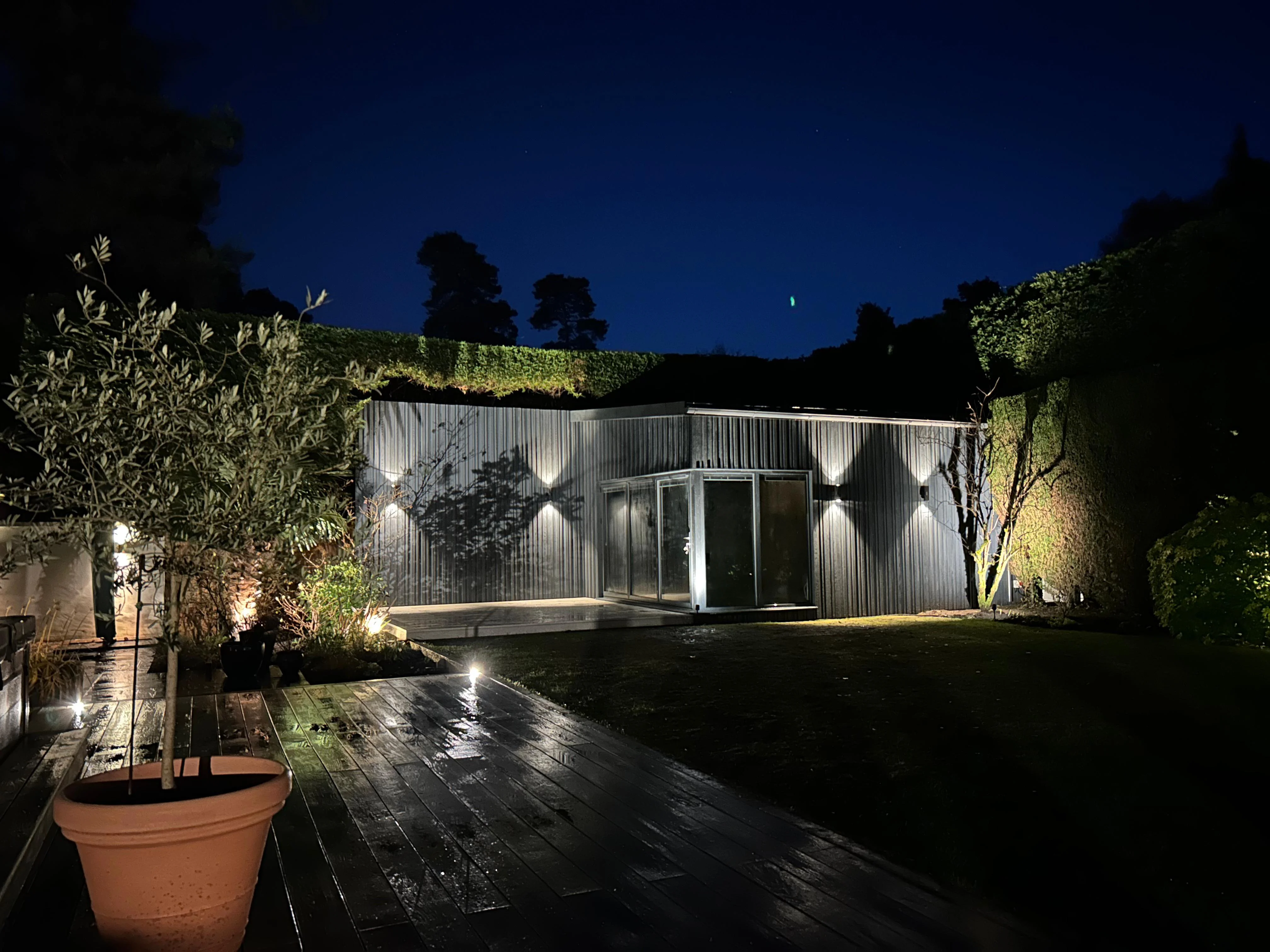Golf simulator garden room at night — Woking, Surrey